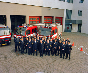 840251 Groepsportret van een groep personeelsleden van de Brandweer Nieuwegein, bij de brandweerkazerne ...